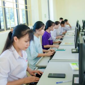 Young students engaged in a computer lab, focused on learning and collaboration.