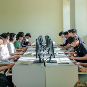 A group of students in a classroom focused on computer screens, fostering digital education.